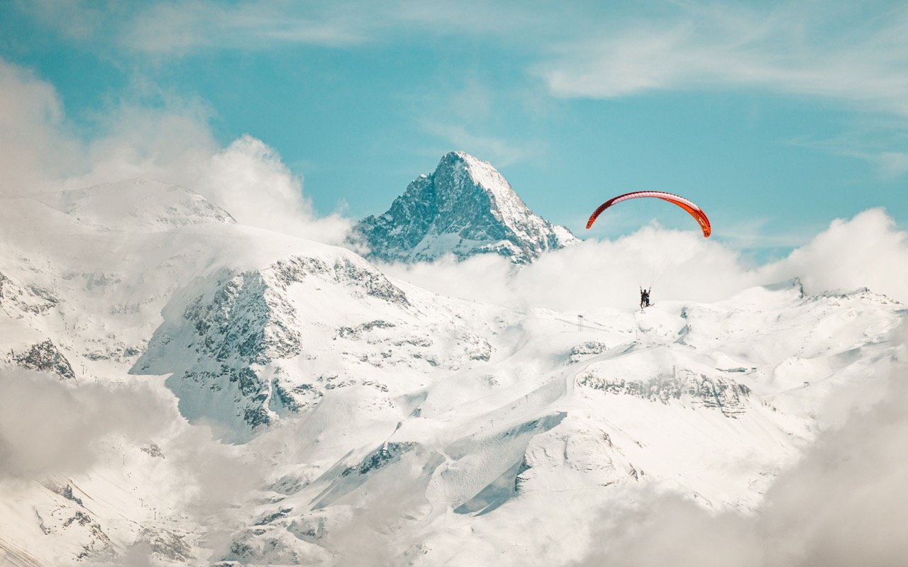 A paraglider flying over the French mountains.
